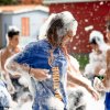 Persone si divertono in una festa con schiuma all'aperto.