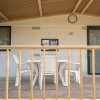Veranda con tavolo e sedie in plastica bianca.