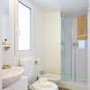 Bagno moderno con doccia e finestra.