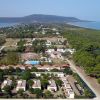 Vista aerea di un complesso turistico vicino al mare circondato da alberi.