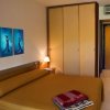Una camera d'hotel con letto matrimoniale, armadio e tre quadri blu.