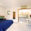 Camera con letto matrimoniale, angolo cottura, tavolo da pranzo e aria condizionata.
