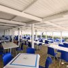 Ristorante all'aperto con tavoli e sedie blu.