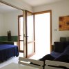 Interno di un appartamento con divano, tavolo da pranzo e porta-finestra aperta.