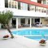 Piscina circondata da tavoli apparecchiati e un edificio con finestre.