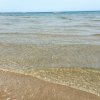 Mare con onde leggere che arrivano sulla spiaggia sabbiosa.
