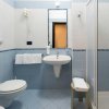 Un bagno con piastrelle blu, lavandino, doccia e WC.