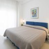 Camera da letto bianca con letto matrimoniale blu.