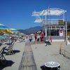 Spiaggia con chiosco e ombrelloni colorati.