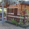 Casetta in legno con veranda e alberi.