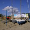Barche sulla spiaggia con striscione vela.