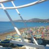 Vista sulla spiaggia con ombrelloni colorati e mare.