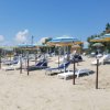 Ombrelloni e lettini sulla spiaggia sabbiosa.