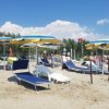Spiaggia con lettini blu e ombrelloni gialli.