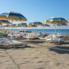 Sdraio e ombrelloni gialli e blu sulla spiaggia.