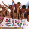 Bambini sorridenti mostrano un cartello colorato con la scritta 