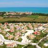 Villaggio turistico con villette colorate vicino al mare.