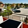 Balcone con tavolo e sedie, vista su parcheggio.