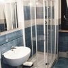 Bagno con lavabo bianco e cabina doccia in vetro.