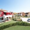 Edifici colorati con auto parcheggiate e un giardino verde.