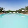 Ampia piscina con lettini e ombrelloni.