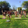 Gruppo di persone che fa esercizi all'aperto su un prato.
