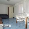 Monolocale con divano, armadio e tavolo.