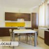 Bilocale con cucina moderna e tavolo.