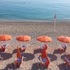 Spiaggia con ombrelloni arancioni allineati.
