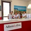 Quattro persone sorridenti al banco della reception.