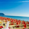 Spiaggia con ombrelloni arancioni e mare.