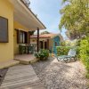 Bungalow giallo con veranda e sedie da giardino.