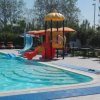 Piscina con scivoli per bambini e ombrelloni.
