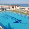 Piscina all'aperto vicino al mare con lettini.