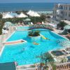 Piscina con scivolo, ponticello e persone che nuotano.