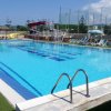Piscina grande con lettini e ombrelloni intorno.