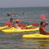Persone in kayak gialli sul mare.