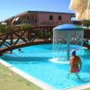 Piscina con ponte di legno e fontana d'acqua sotto il sole.