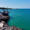 Scogliere con una struttura di legno per la pesca sul mare turchese.