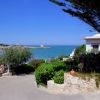 Una strada panoramica con vista sul mare, alberi e case bianche.