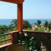 Vista mare dal balcone con fiori e tavolo.