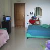 Camera da letto con letto singolo e matrimoniale, TV e mobili in legno.