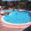 Piscina a forma di cuore con lettini e palme.