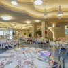Ristorante con tavoli rotondi apparecchiati e illuminazione elegante.