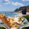Coppa di gelato con cialde e vista mare.
