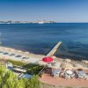 Vista sul mare con lettini e ombrelloni colorati su una terrazza.