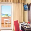 Una stanza d'hotel con balcone vista mare, scrivania con colazione e TV sul muro.