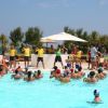 Persone in una piscina partecipano a una lezione guidata da istruttori.