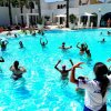Persone in piscina partecipano a un'attività di acquagym sotto la guida di un istruttore.