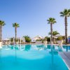 Una piscina con palme intorno e cielo limpido.